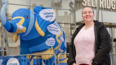 Student looking towards the camera standing in front of an inflatable elephant