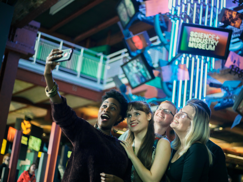 Five students take a selfie in a public space