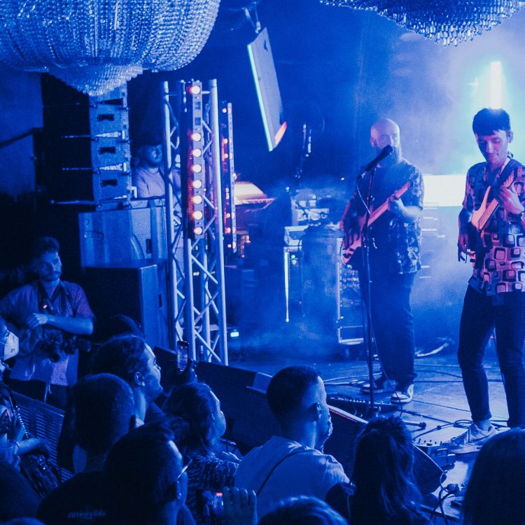 Musician on stage performing to a crowd of people