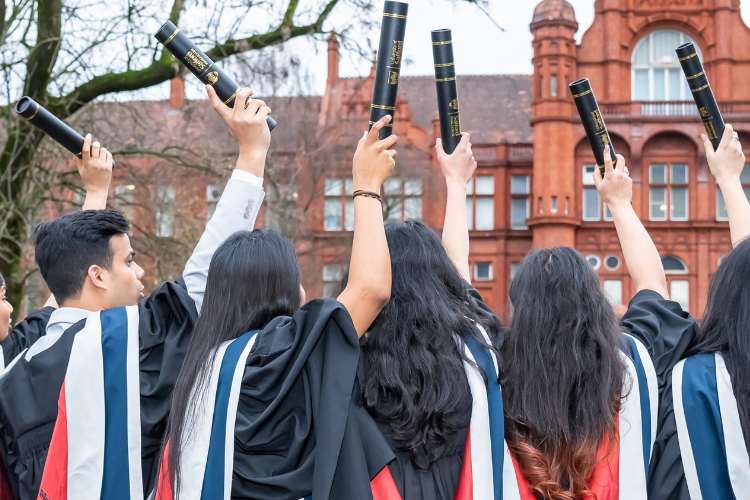 group of students at graduation holding up their scrolls