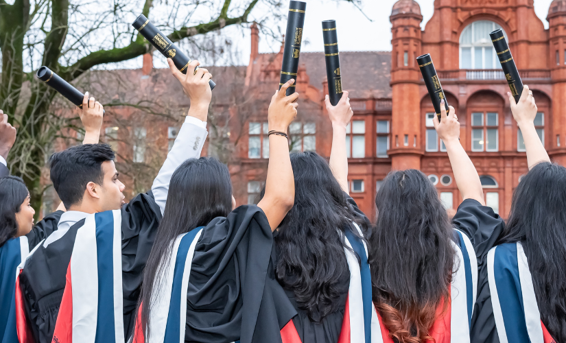 group of students at graduation holding up their scrolls