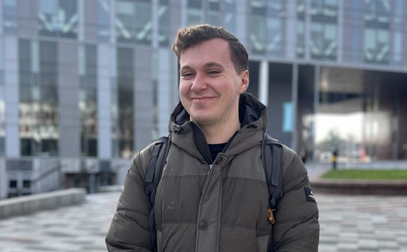 James Donaldson smiling in front of the New Adelphi building.