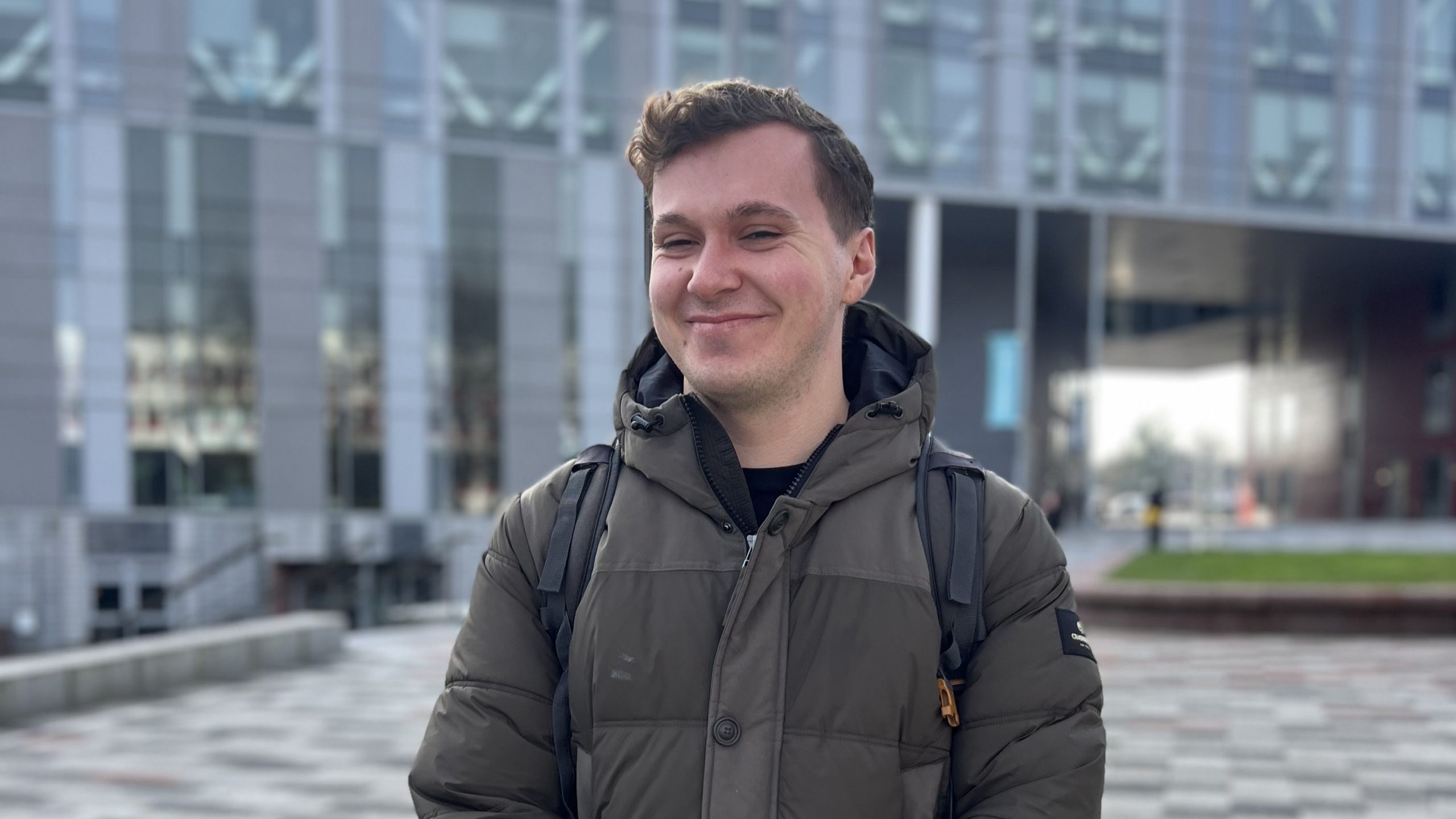 James Donaldson smiling in front of the New Adelphi building.