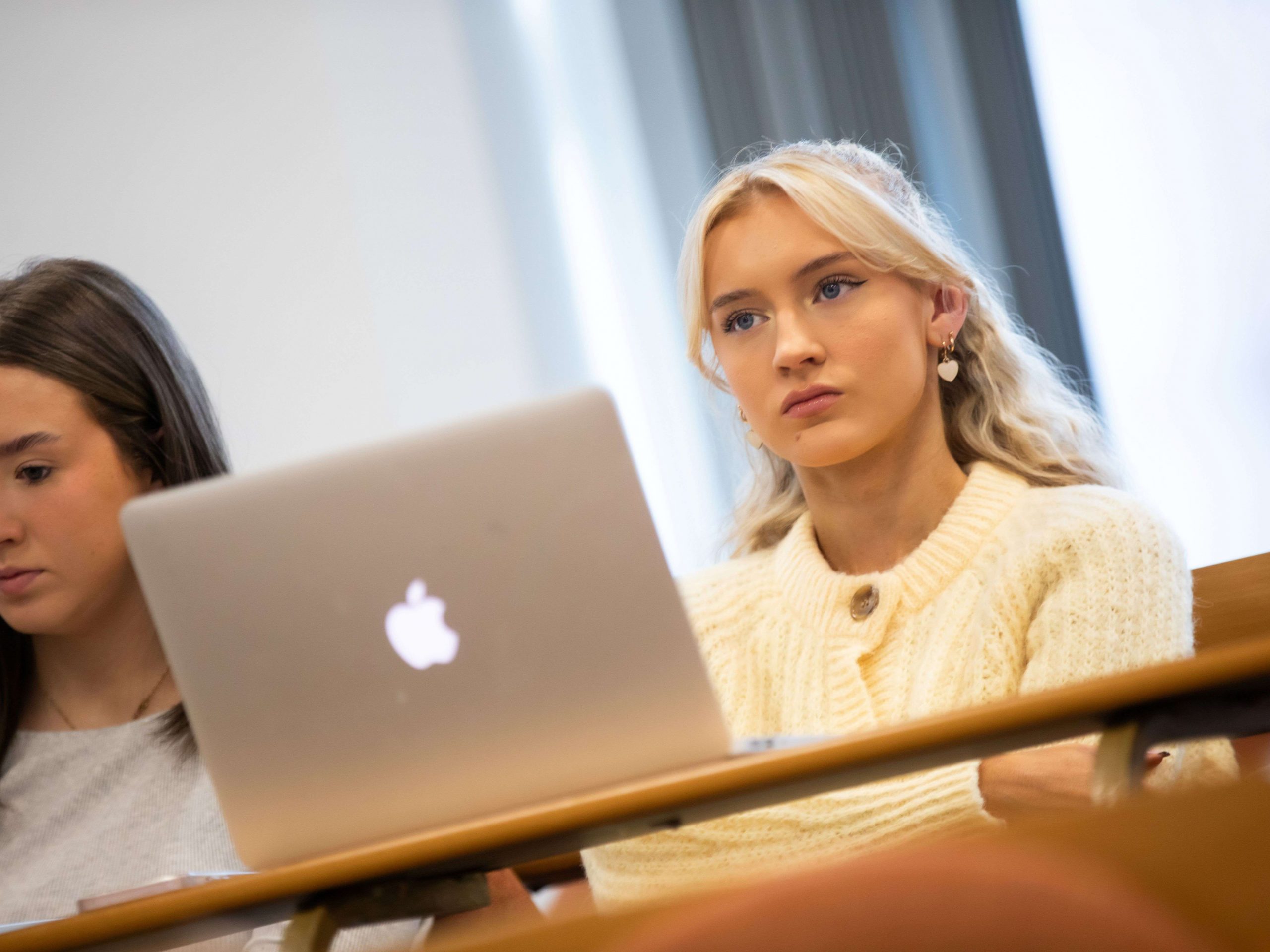 Students attending a lecture, sitting at a desk.