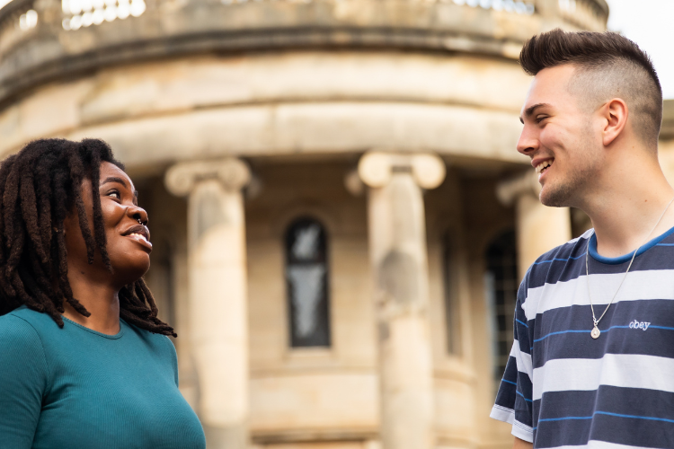 Two students are talking to each other on Chapel Street.