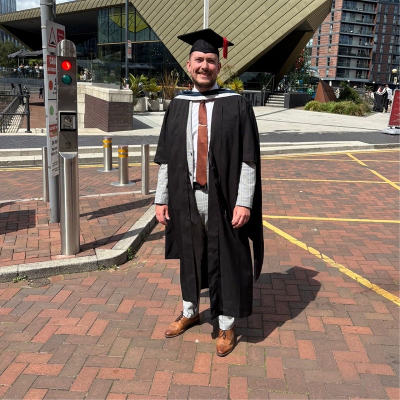 MSc Project Management student Ben Crossley at his graduation, wearing a cap and gown.