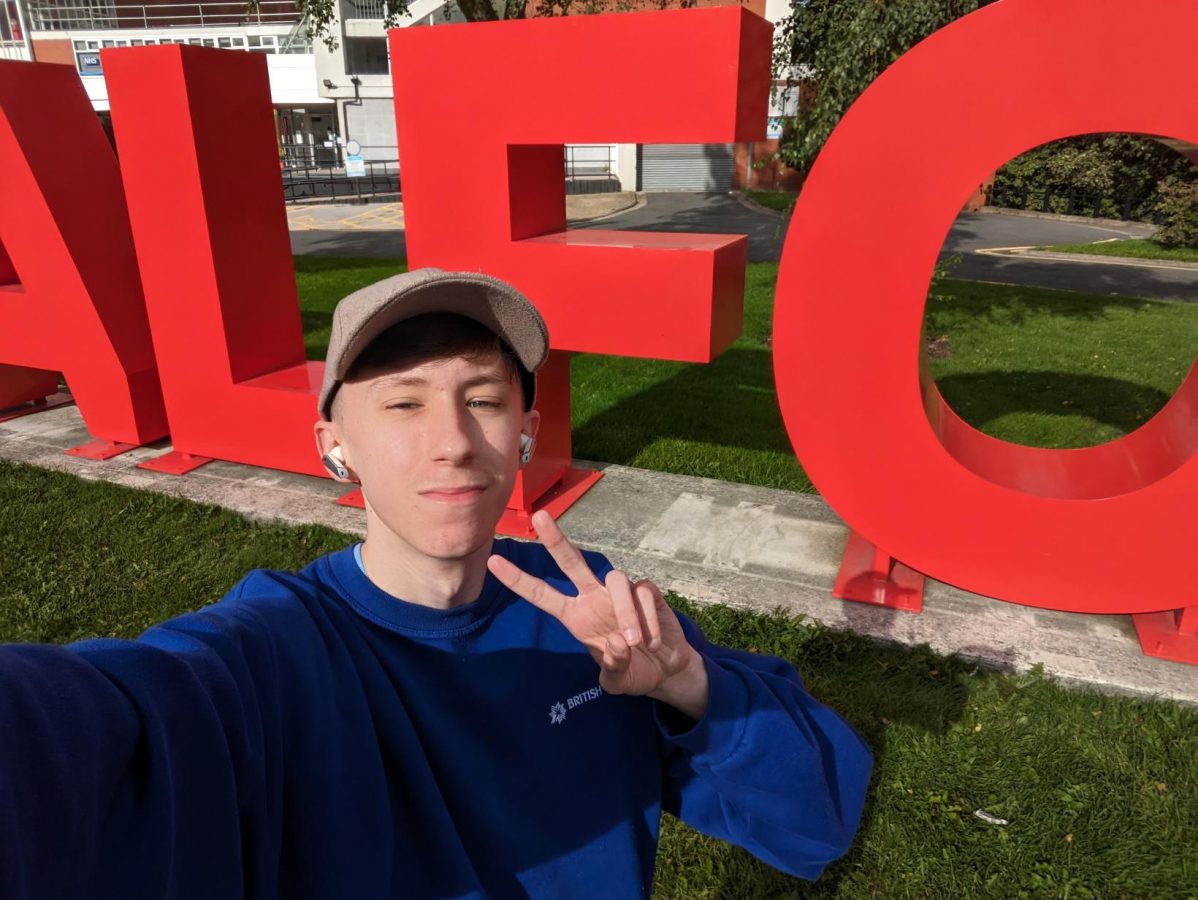A selfie of Josh next to the SALFORD sign