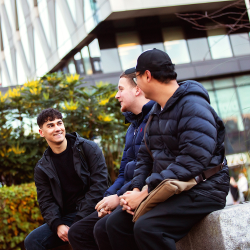 Three students talking outside MediaCity building