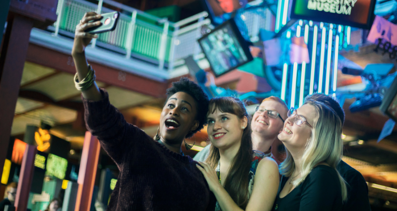 Five students take a selfie in a public space